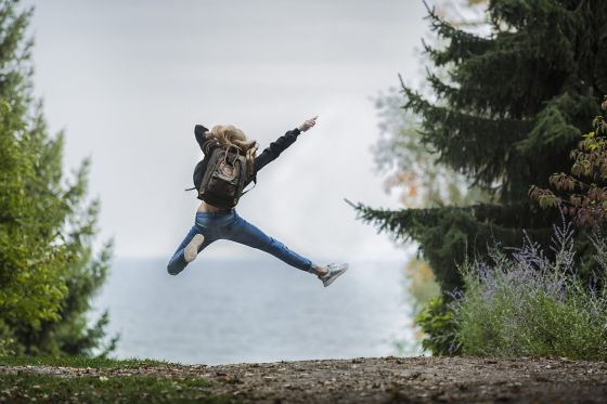 kvinde hopper gld af sted på en sti i naturen